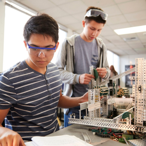 Students working together on a laptop in a workshop